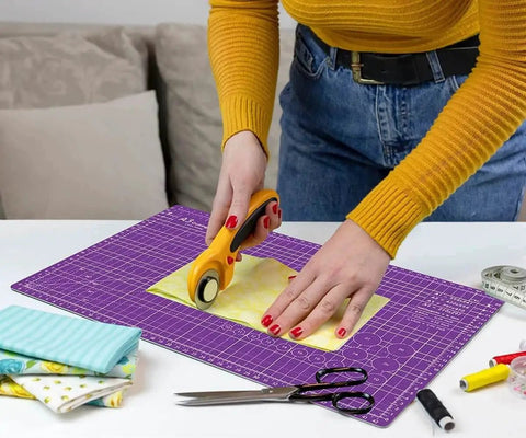 Person using a rotary cutter on a Thickened Self Healing Cutting Mat 18x12 Inch A3 Rotary Cutting Sewing Mat, purple surface.