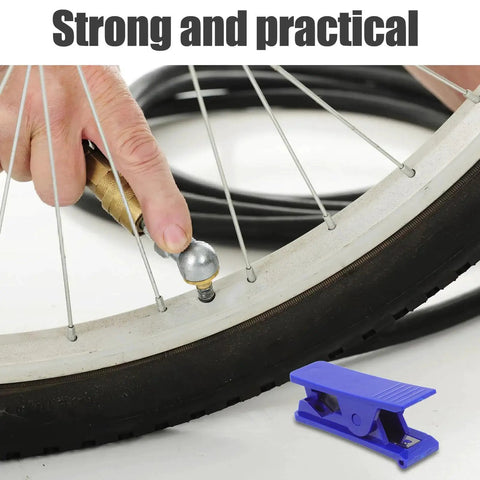 Close-up of TEHAUX bike hydraulic brake hose cutter tool on a bicycle wheel; blue plastic clip in foreground