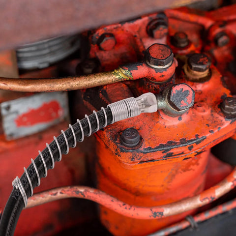 NQEUEPN grease gun hose with coupler, 18-inch spring-flex, attached to a red metal housing.