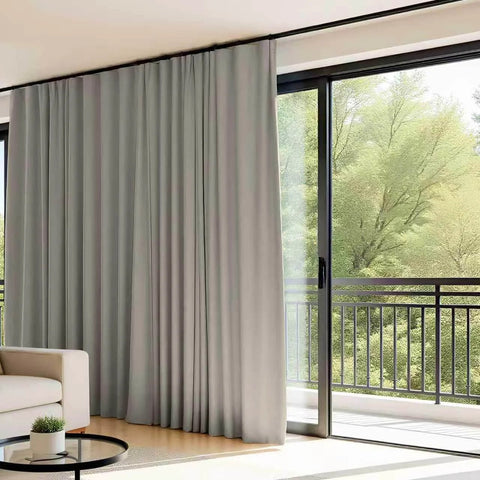 Flexible Ceiling Track Curtain System For L Shaped Or U Shaped Installations with light grey drapes in a living room.