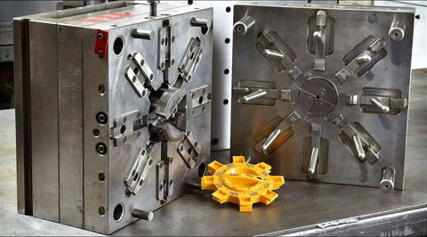 Industrial metal mold with yellow plastic component on table
