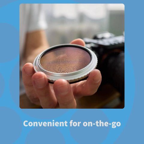 Person holding camera lens, showcasing Optics Cleaning Solution With Microfiber Cloth For Smudge Free Lenses 2 Oz in use.