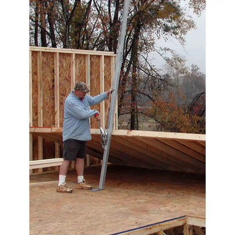 Worker using Telescoping Wall Jack Pair For Sheathed Walls Up To 70 Feet And 16 Foot Lift on a construction site