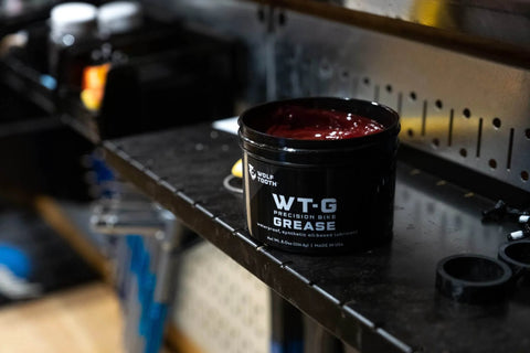Precision Bike Grease for All Weather Performance, Ultra Low Viscosity Lube in black container on workshop shelf, 2 Oz.