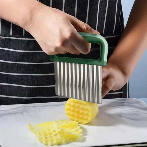 Person using a Crinkle Cutter For Veggies And Potatoes With Protective Case And Handle Stainless Steel Wave Cutter For Carrot Slicer French Fry Cutter Onion Chopper Green Durable 0.02 Inch Blade Measures 3.54 By 2.75 Inches on a potato.
