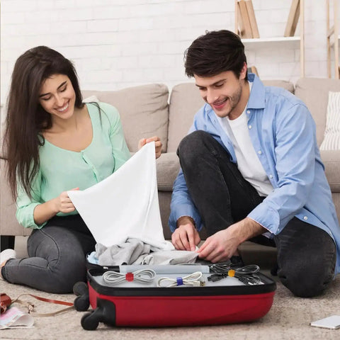 Couple packing suitcase with multicolor nylon fabric cable ties with reusable hook and loop fasteners for cable management.