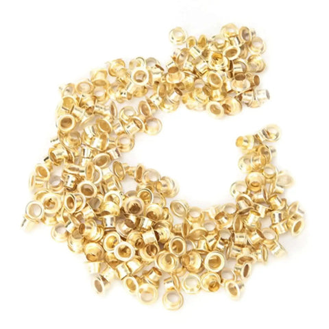 Gold metal grommets from Pro Grade Grommet Tool Kit for Tarps, Fabric, and Leather, heavy-duty metal retainer kit for quick binding.