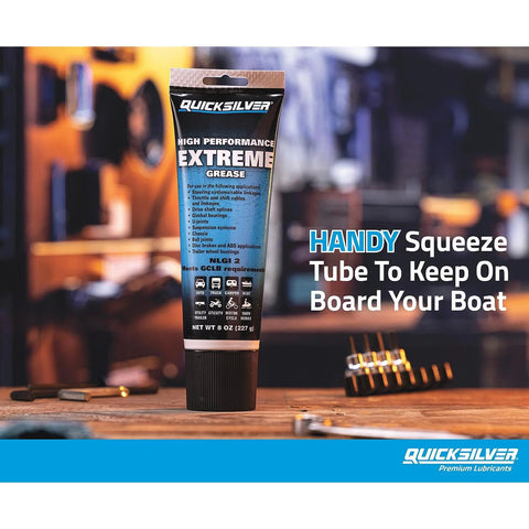 Quicksilver 8 oz high-performance extreme marine grease tube, NLGI 2, front view on workbench with tools.