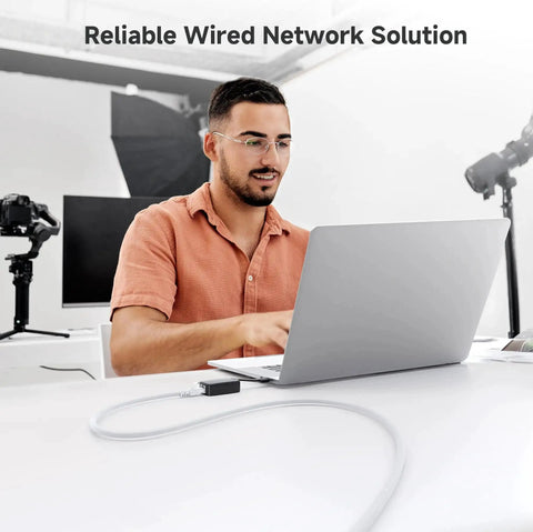 Man using laptop with 10Gbps Snagless Cat6 Ethernet Cable 5ft Multi Color Set for Fast LAN Connections, office setting