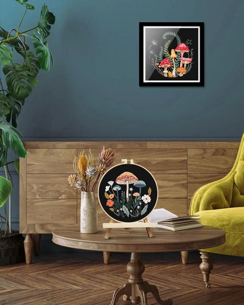 Two Pack Embroidery Kit For Grownups Beginner Friendly With Mushroom Pattern Hoops Tools Colorful Threads Needles And Step By Step Instructions DIY Starter Set featuring a completed mushroom embroidery displayed on a wooden table in a living room with a green chair and wooden cabinet.