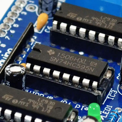 Close-up of L293D Motor Drive Shield For Arduino And Raspberry Pi with electronic components, showing SN74HC595N chip, blue circuit board