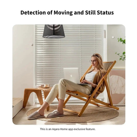 Person sitting on a chair with a laptop, showcasing FP1E Zigbee Presence Sensor With MmWave Radar, Wired Motion Sensing And AI Spatial Learning.