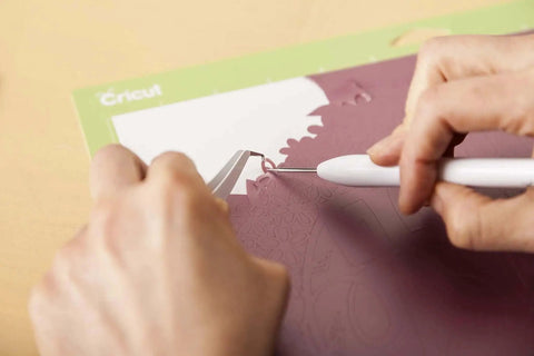 Using the Go-To 5-Piece Craft Tool Set for Precision Lifts Snips Burnish and Weed by Cricut on a purple paper design