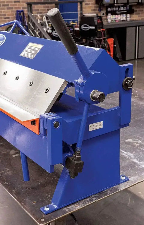 Close-up side view of 48 Inch Pan And Box Sheet Metal Brake with adjustable removable fingers in blue for 135° bends, workshop setting.
