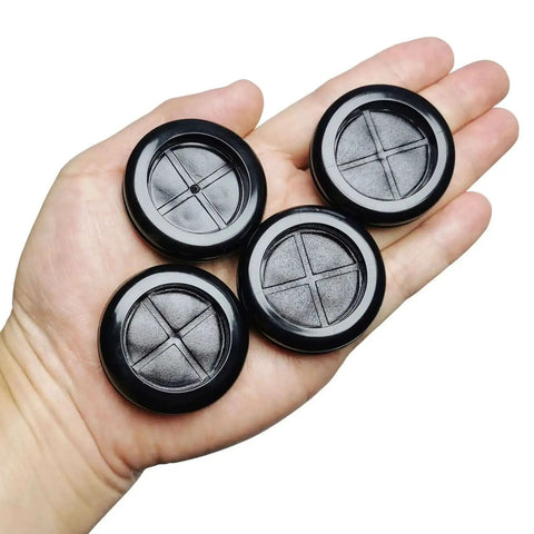 Hand holding four black rubber grommets for 1.5-inch holes, Eight Pack One And A Half Inch Drill Hole Rubber Grommets Black Double Sided Cable Plugs For Wire Protection Durable Natural Rubber Dust Proof Insulation For Wiring Harnesses Great For Automotive Wiring And Electrical Projects.