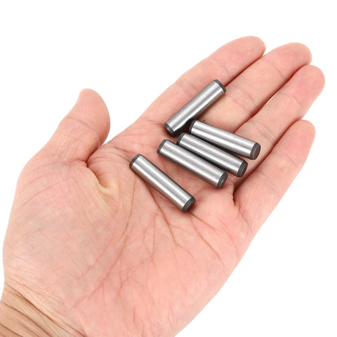 Hand holding five Beefy 5/16 Inch By 1-1/4 Inch Dowel Pins in heat-treated alloy steel, bright finish, for precise alignment.