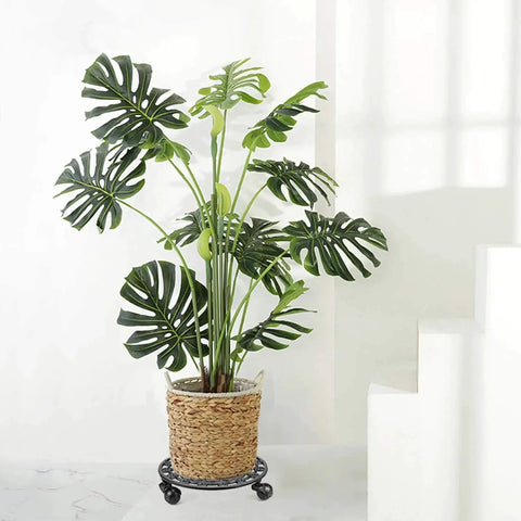 Heavy Duty Cast Iron Plant Stand On Wheels for Indoor and Outdoor Use with a large planter and lush green leaves