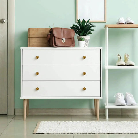Antique Brass Round Cabinet Knobs 6 Pack on white dresser in modern minimalist room.
