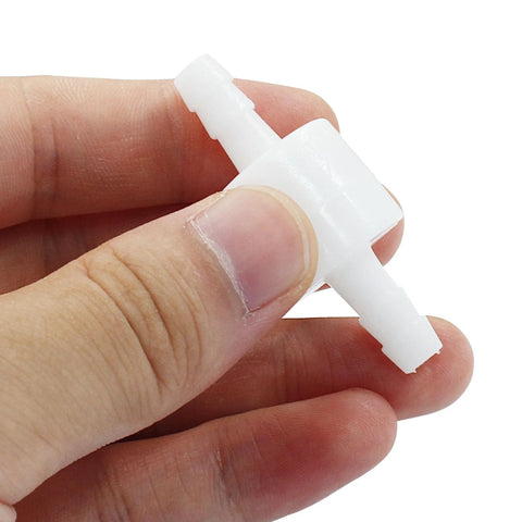 Close-up of 1/4 inch inline PVDF plastic check valve with barbed ends, white, held by fingers