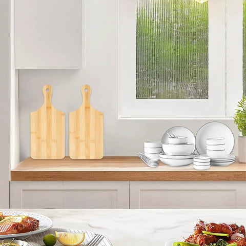 Two bamboo boards with handles on kitchen countertop, Bulk 25 Pack Mini Charcuterie Boards Set For Pizza Bread Cheese Fruit And Serving Bamboo Cutting Boards With Handle 11 By 5 Inch Laser Engraving Ready Great For Gifting DIY Projects Eco Friendly Kitchen Essentials.