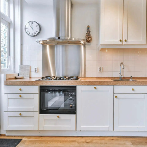 Antique Brass Round Cabinet Knobs 6 Pack installed on white kitchen cabinets with wooden countertop, modern kitchen decor.