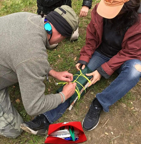 Person applying a splint with materials from a Pack Of 12 Empty First Aid Kit Pouches For Travel And Outdoor Emergencies Waterproof Nylon 20 By 14 Cm.