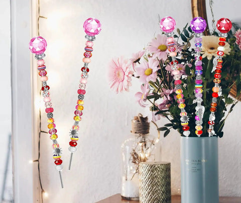 Colorful beaded garden stakes with decorative tops displayed in a vase