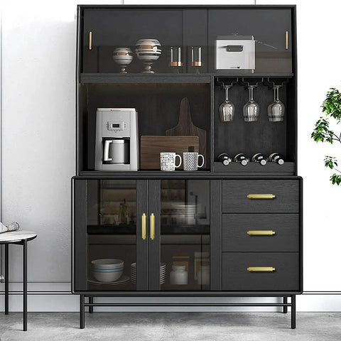 Modern kitchen cabinet with black finish, showcasing glassware, mugs, and a coffee maker. Gold pull handles for wardrobe cabinets.