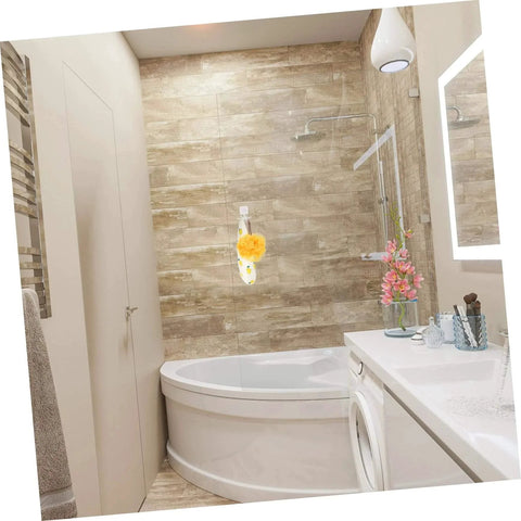 Modern bathroom with corner bathtub, hanging bath sponge, and vibrant flowers on a sleek white countertop.
