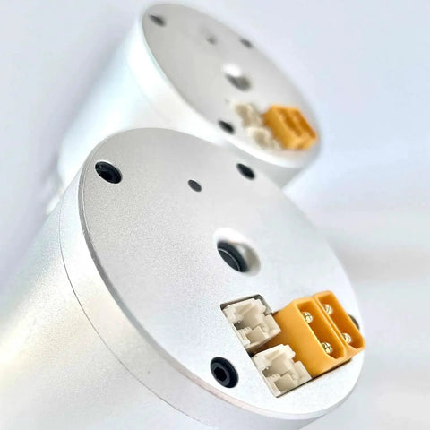 Silver hollow harmonic servo motor joint module with orange terminal blocks and white connectors.