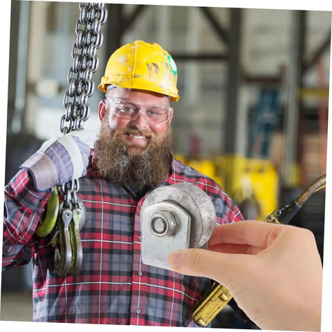 Worker holding a Heavy Duty V Groove Wheel Pulley Caster for Sliding Gates and Garage Doors with cast iron wheel and low friction bearings