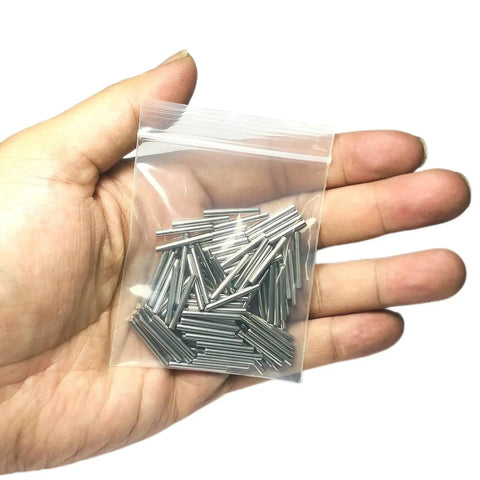 Hand holding bag of 100 Pack 2mm By 20mm Dowel Pins Metal Dowel Pins M2 For Wood Furniture Shelves 304 Stainless Steel Shelf Pegs