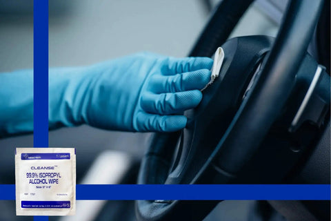 Gloved hand using 99.9 Percent Isopropyl Alcohol Wipes For Electronics And Screens on a car steering wheel