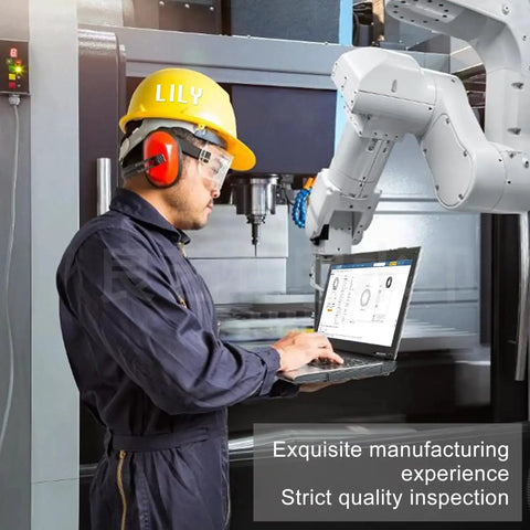 Manufacturing worker with protective gear uses laptop near robotic arm, emphasizing quality inspection process in factory