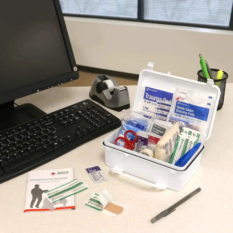 All Purpose 57 Piece Emergency First Aid Kit for 10 People on office desk with bandages, gauze, scissors