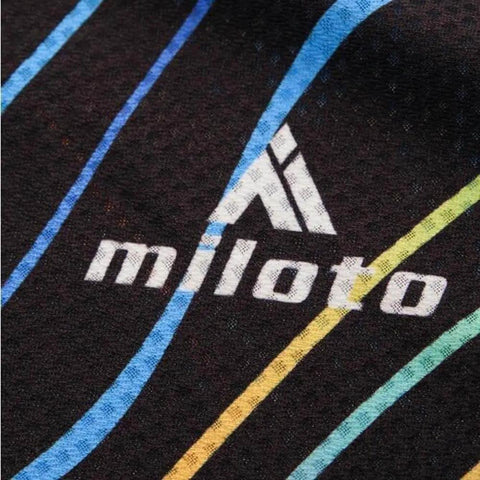 Close-up of fabric with colorful stripes and 'miloto' logo on dark background.