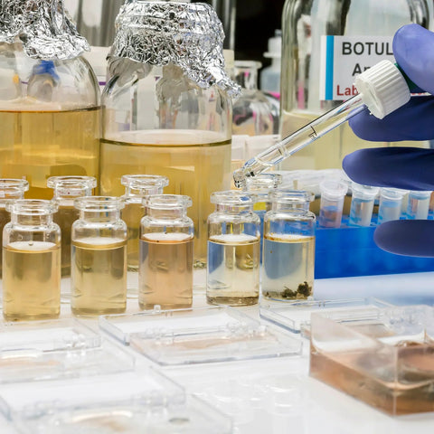 2ml sterile glass injection vials with plastic-aluminum flip caps in a lab, filled with pale liquid