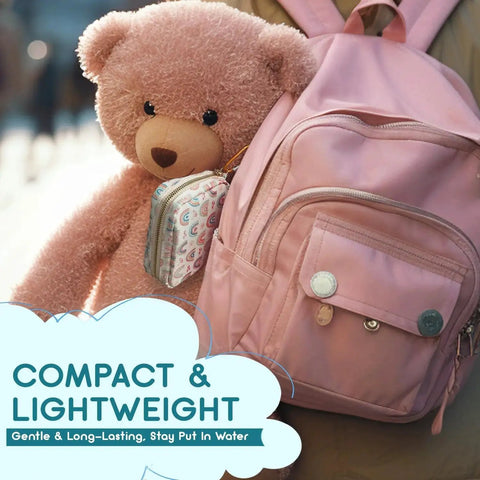 Compact pink backpack with Pocket Size 105-Piece First Aid Kit For Families And Kids attached, teddy bear in background.