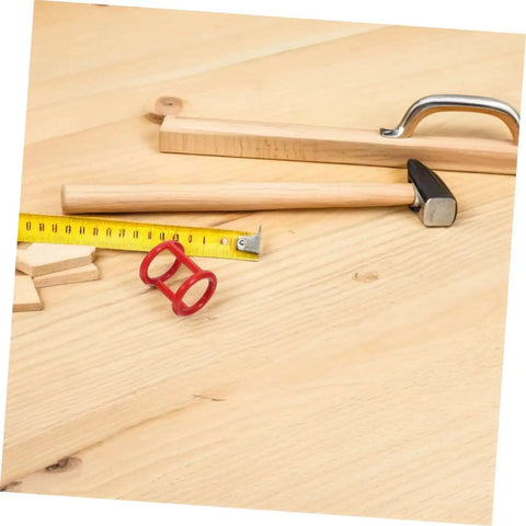 Woodworking tools and accessories on a wooden workbench, including a hammer, measuring tape, and handle
