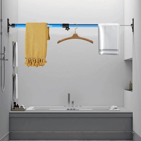 Mounted blue telescopic pole above bathtub used for hanging towels and clothes in a bathroom setting.
