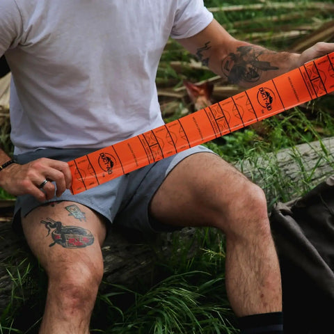 Person using Compact First Aid Kit With Medical Grade Adhesive For Emergency Response Ready For Quick Field Fixes in outdoor setting