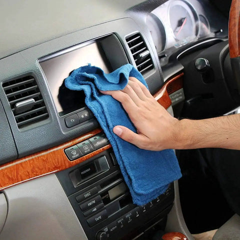 Person cleaning car dashboard with 90 Pack Blue Cotton Shop Towels 14 By 12 Inches Reusable Rags For Auto Garage Industrial And Home Cleaning Absorbent Cloths For Tough Messes And Heavy Duty Jobs Pre Wash In Warm Water Recommended.