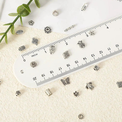 Tibetan Silver Spacer Beads 1000 Pieces Metal Beads For Jewelry Making next to a white ruler showing random styles and mixed shapes.