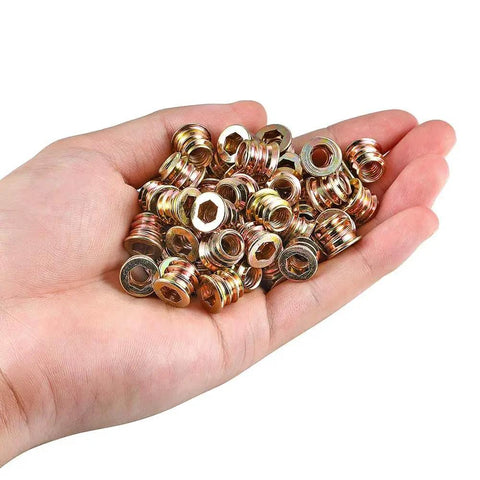 Person holding 80 pieces one quarter twenty wood threaded inserts for furniture bolts with hex socket drive in palm
