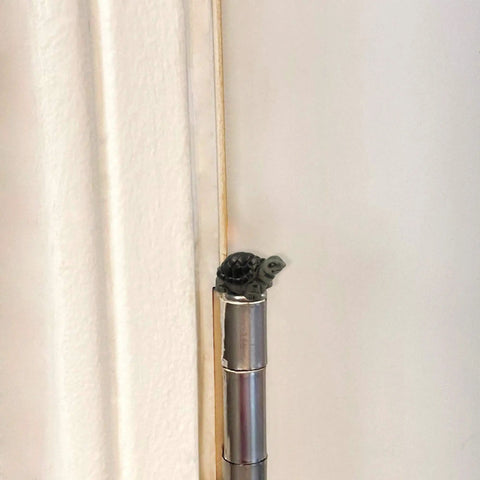 Tiny magnetic turtle head ornament on door hinge, part of the Cute Tortoise Hinge Heads Decorative Topper Set Of Six For Doors And Metal Surfaces.