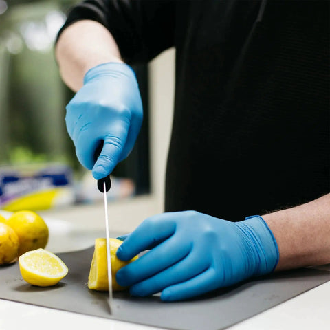 Person wearing Industrial Blue Nitrile Gloves 100 Count Box 3 Mil XX Large Textured Latex Free cutting lemon