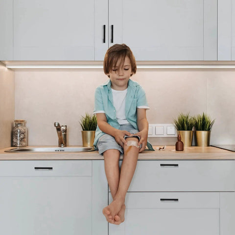 Child sitting on kitchen counter next to cabinets with 3 Inch Wide Foot Cabinet Pulls 10 Pack Matte Black Cabinet Handles installed