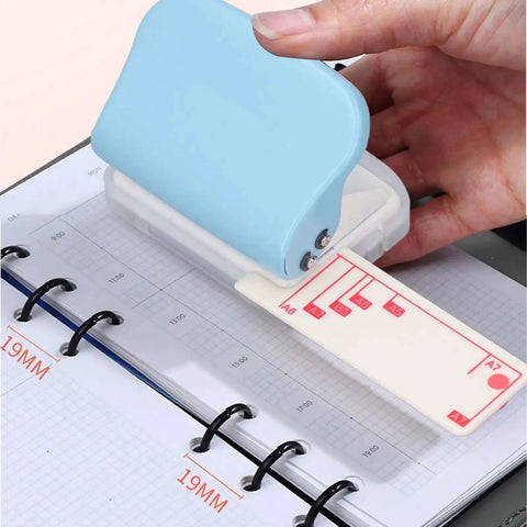 3 Hole Paper Puncher Handheld DIY Tool For B5 Papers Up To 5 Sheets Of 70G being used on a grid planner
