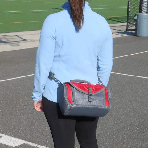 Person carrying All In One Sports Coach First Aid Kit In A Durable Duffel Bag With 189 Pieces for sports coaches outdoors.