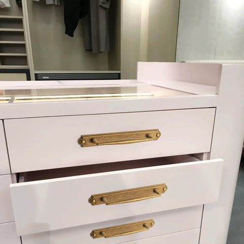 Antique Brass Zinc Alloy Cabinet Handle With Backplate installed on white drawers in a bedroom setting, 5 Inch Center to Center.
